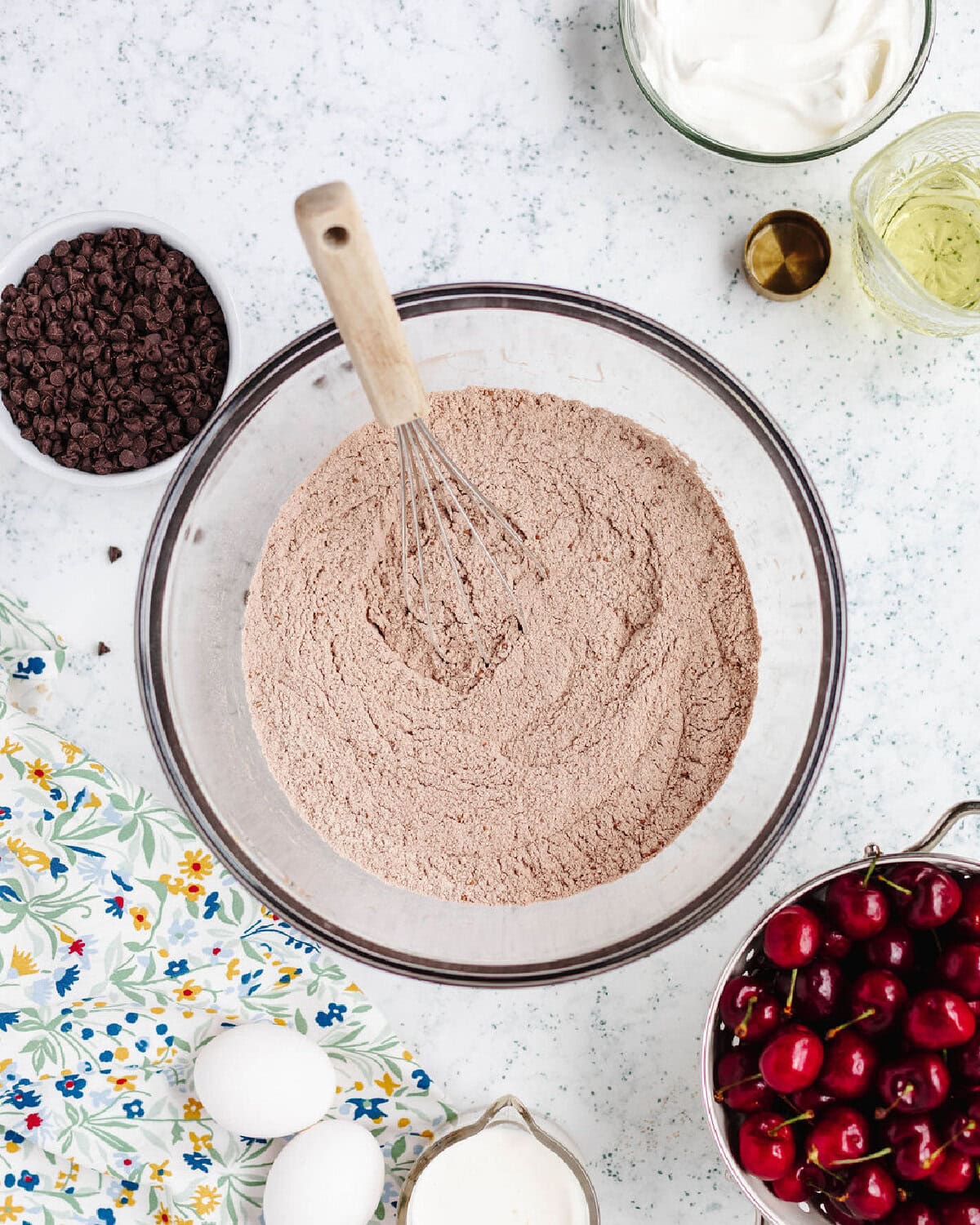 flour, sugar, cocoa powder, baking powder, baking soda, and salt combined in a glass bowl.