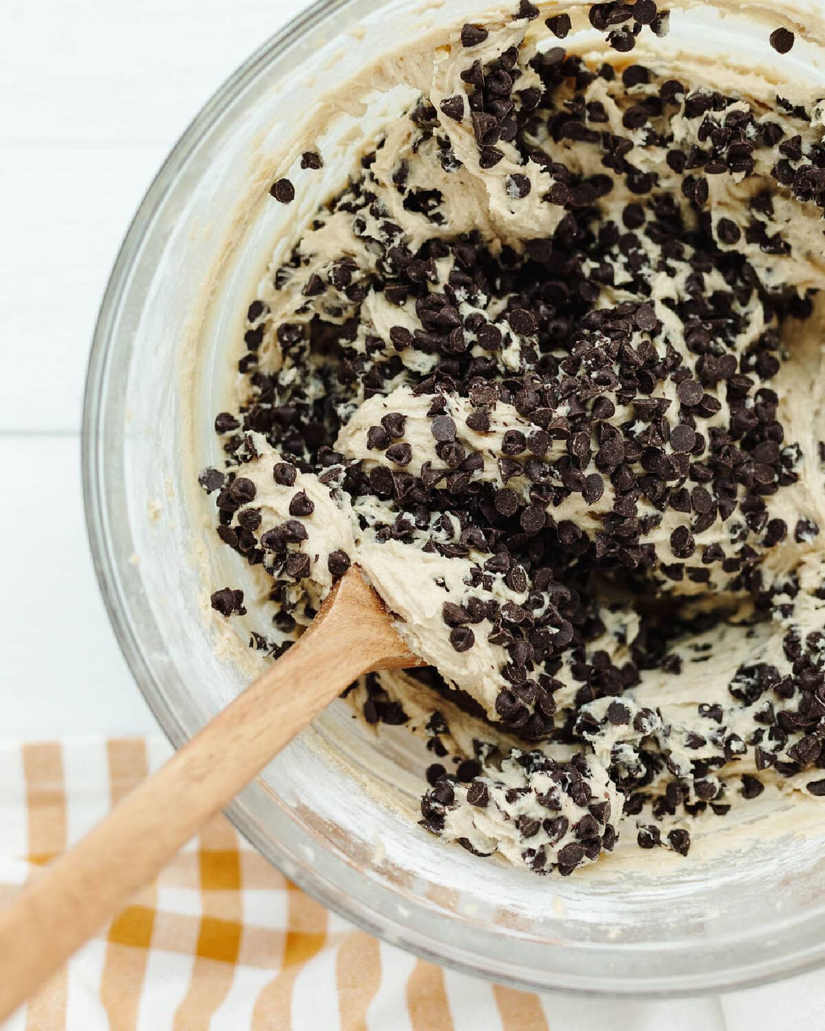 Chocolate chips folded into brownie batter in a mixing bowl.