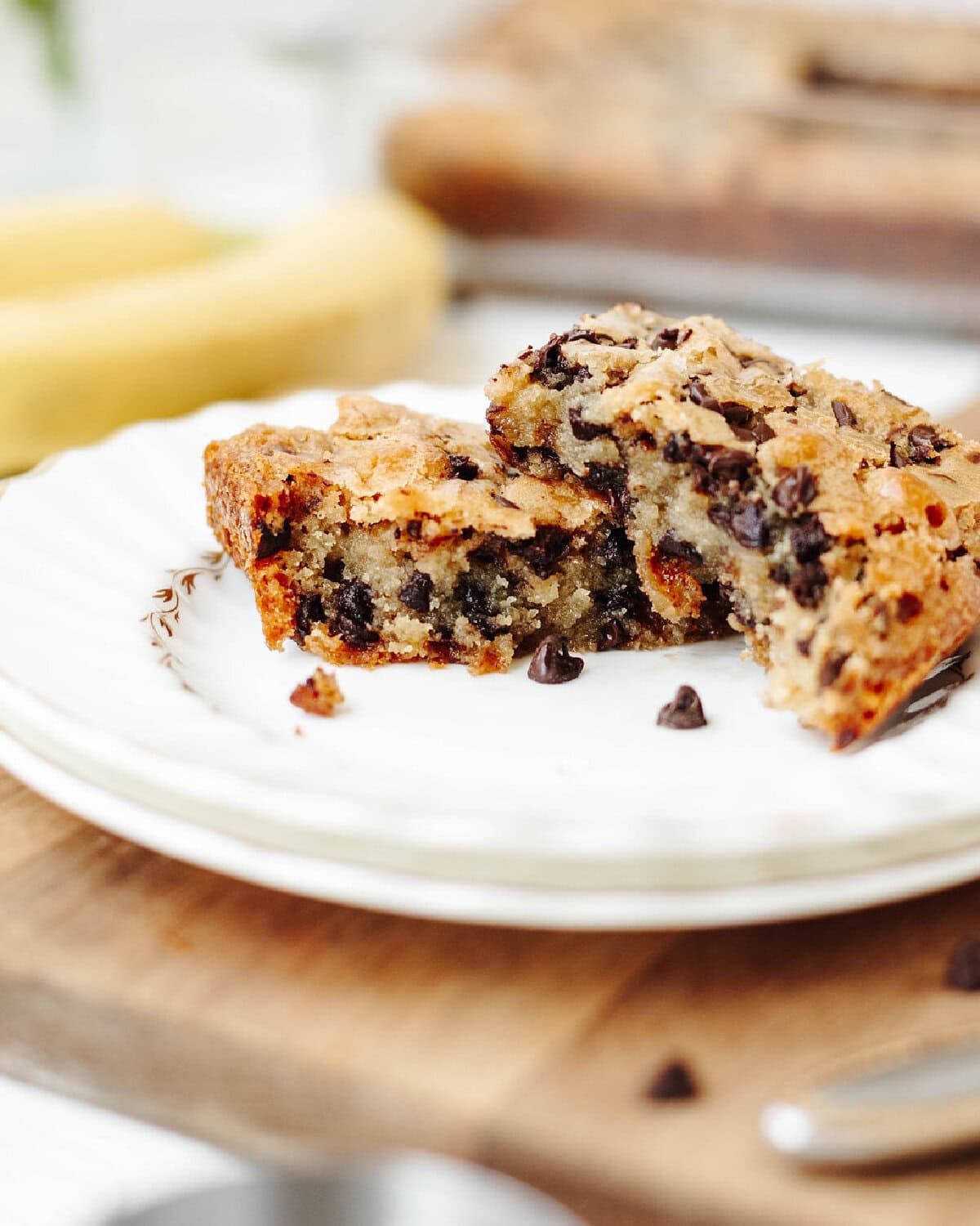 Sliced chunky monkey brownies stacked on a white plate showing the moist texture.