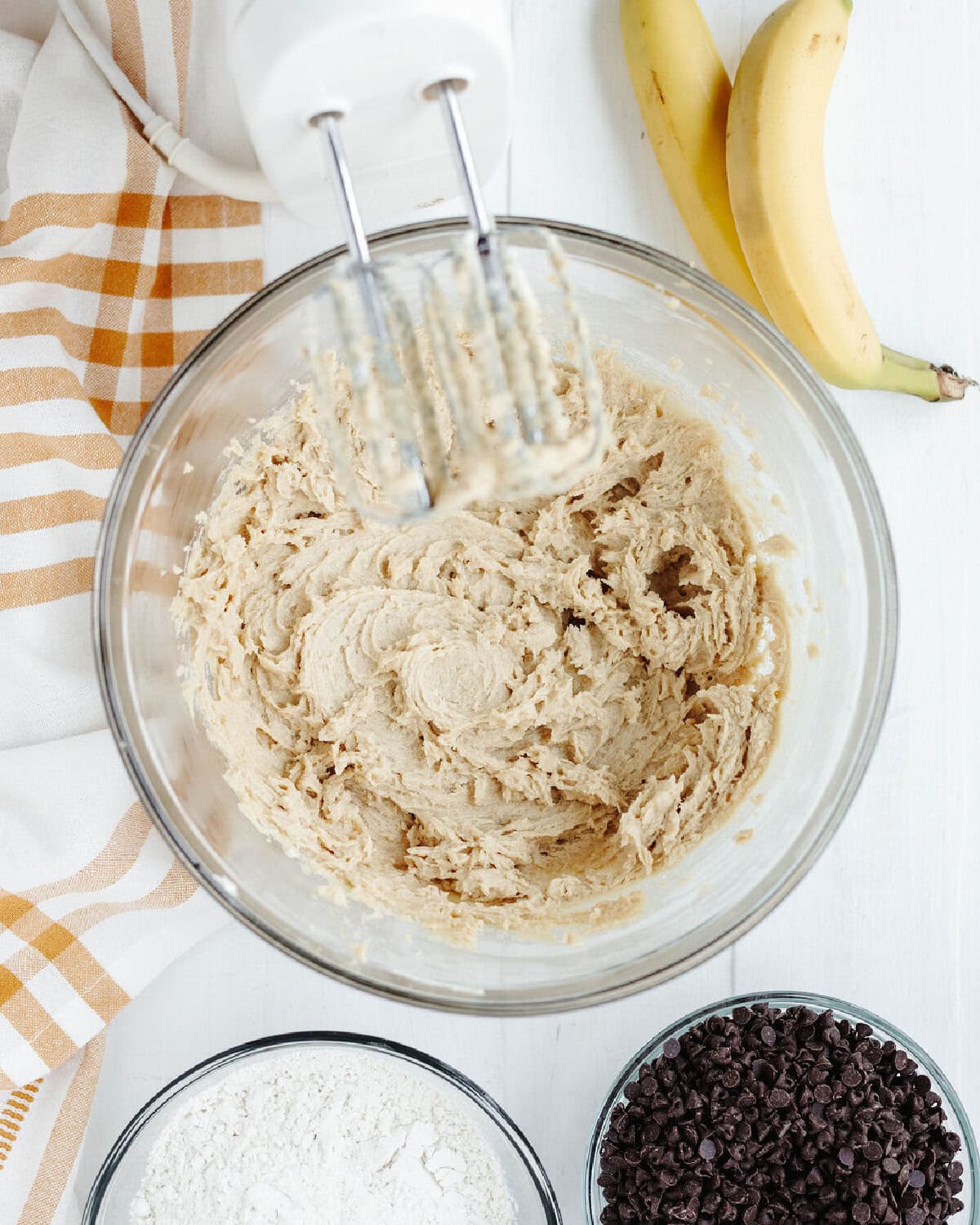 butter, eggs, brown sugar, white sugar, salt, and vanilla creamed together in a glass mixing bowl.