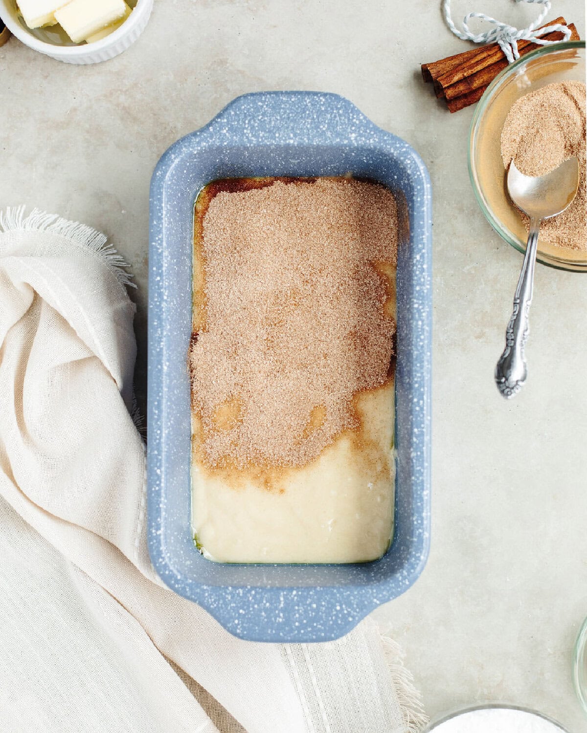 Batter and cinnamon sugar mixture combined in a prepared loaf pan.