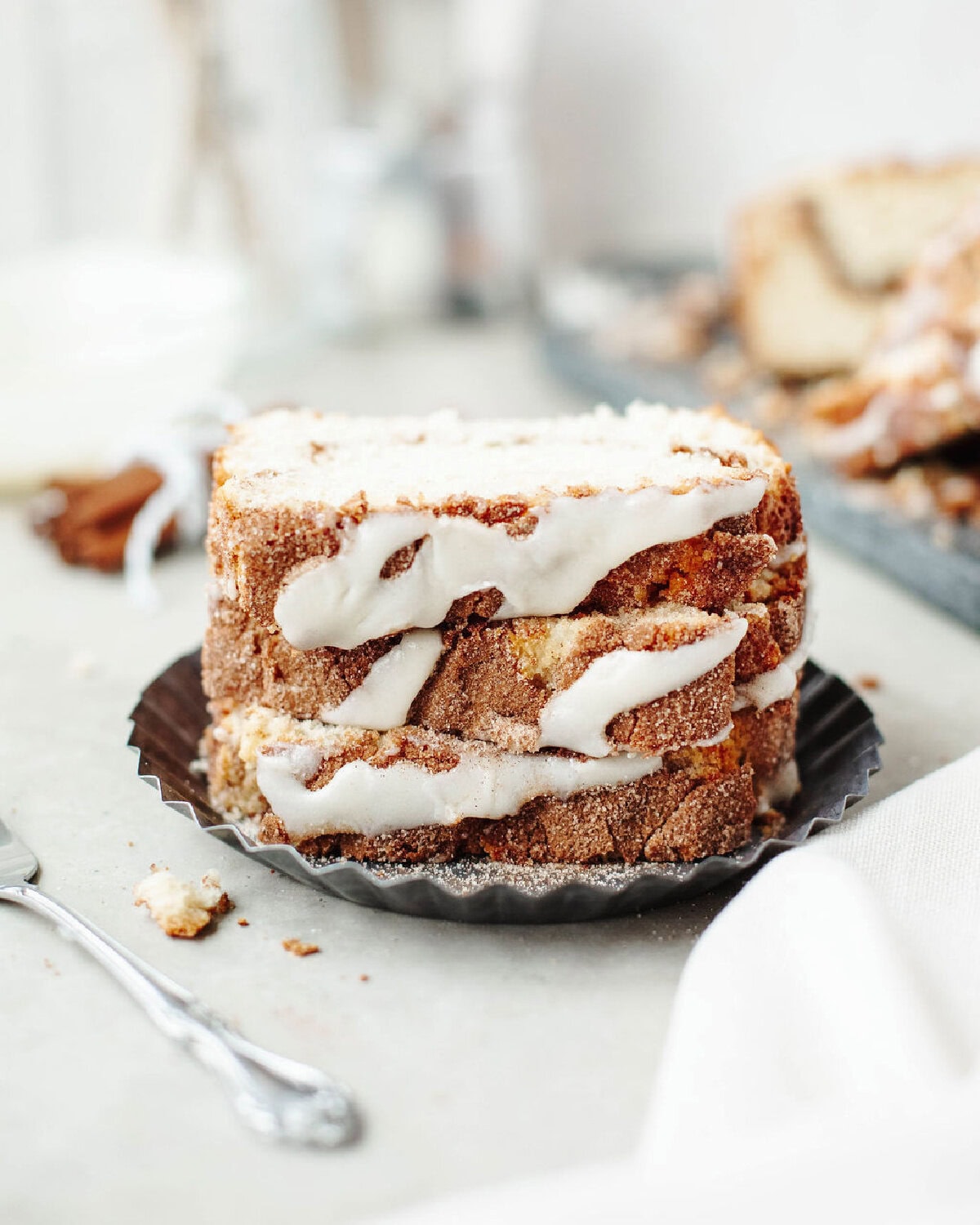 A stack of cinnamon roll bread showing a cream cheese frosting.