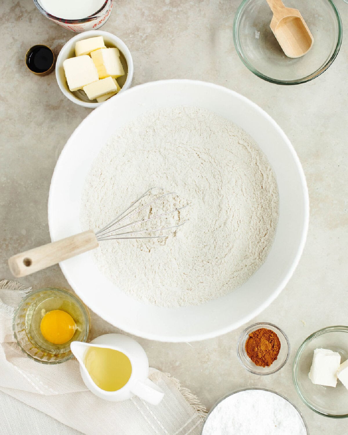 Flour, baking powder, salt, and sugar combined with a whisk in a mixing bowl.