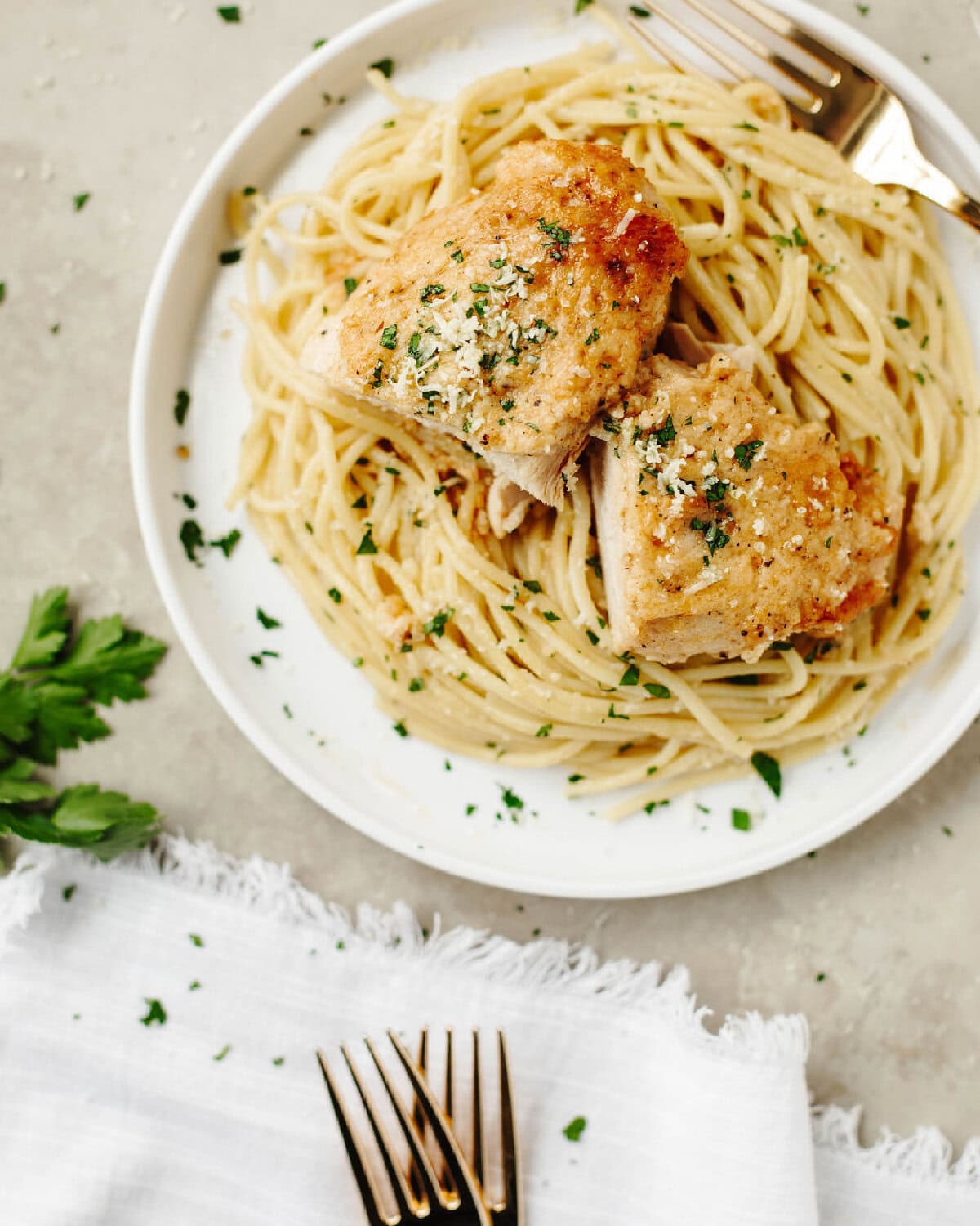 Melt in your mouth chicken made in the crockpot and served over pasta on a white plate.