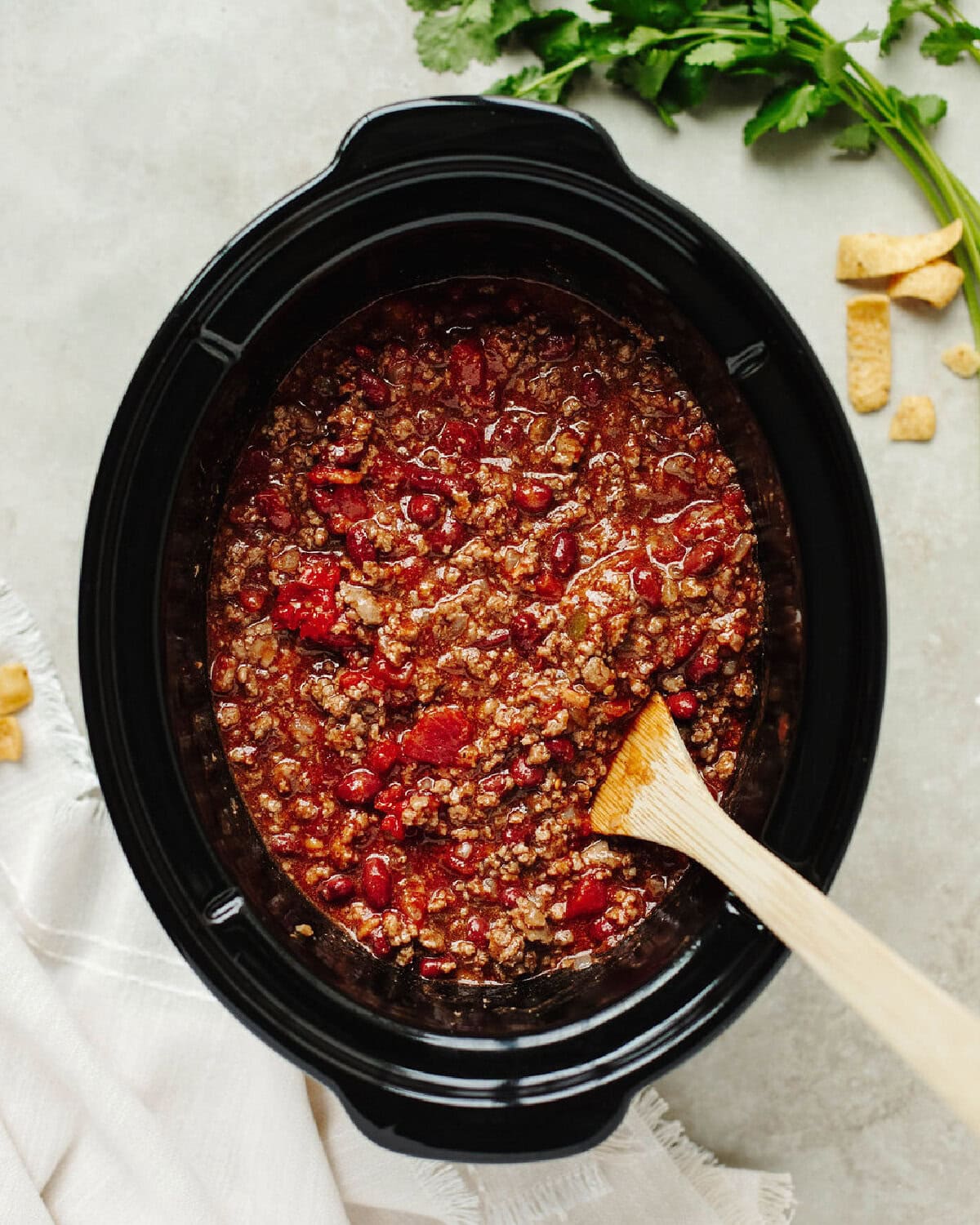 Rotel, tomato sauce, seasonings, and ground beef combined in a slow cooker.