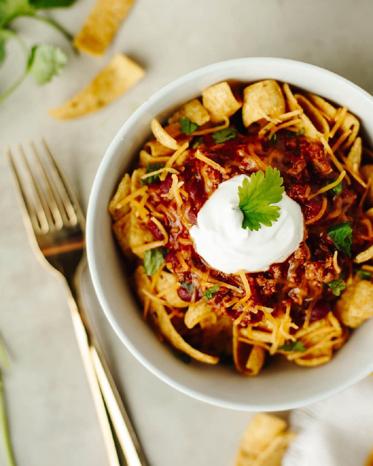 Crockpot Frito Chili Pie in a white bowl with sour cream.