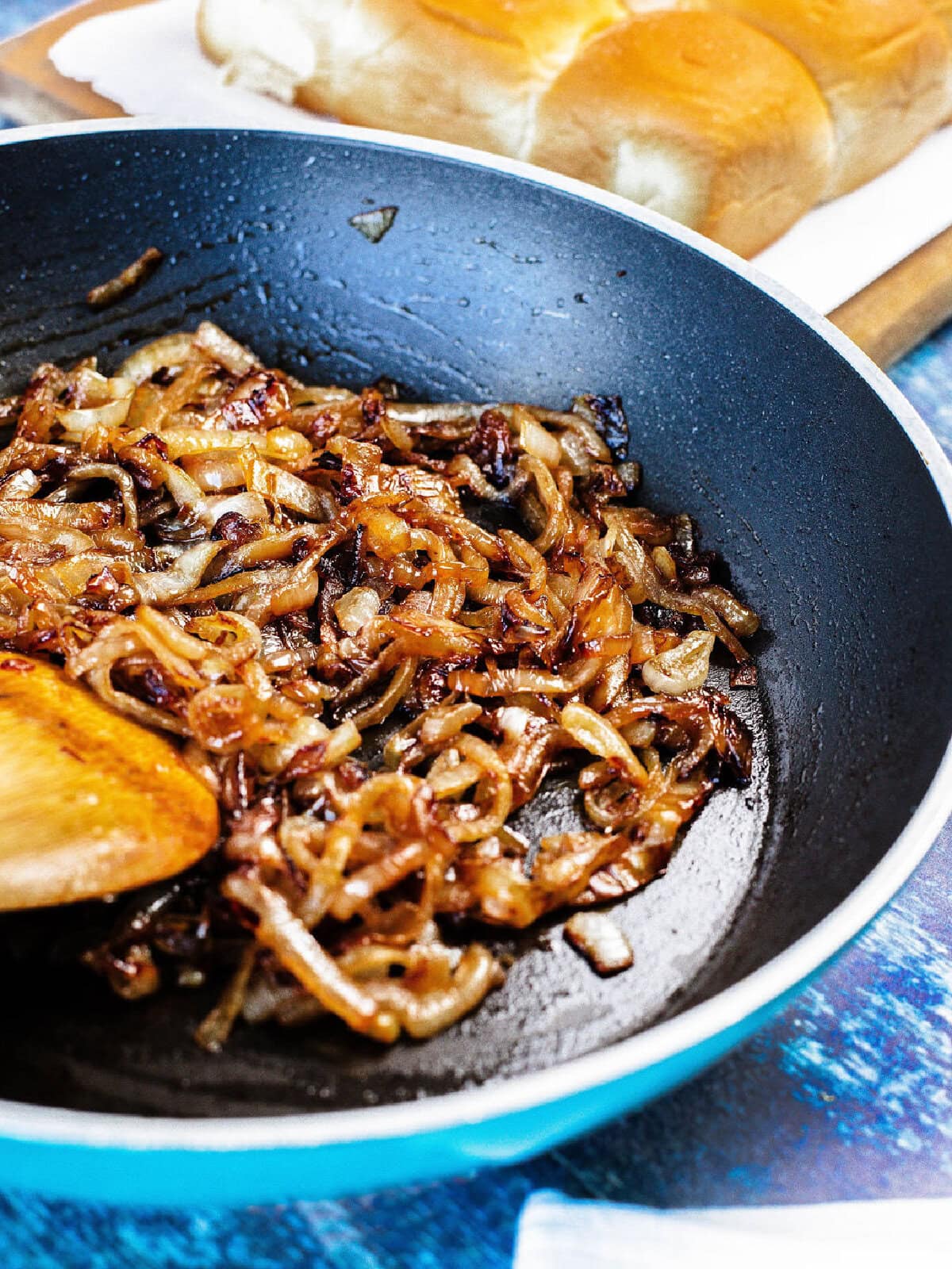 Onions cooking in a skillet with Worcestershire sauce.