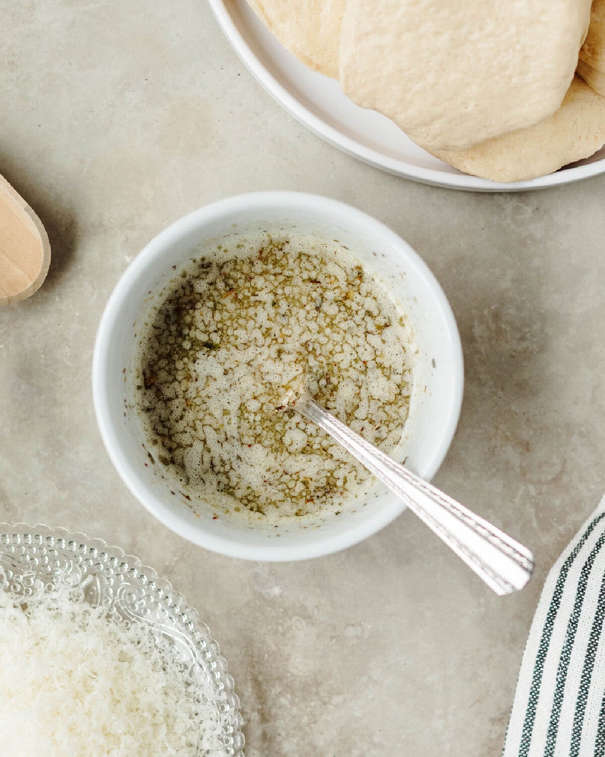 Melted butter combined with Italian seasoning, salt, and garlic powder in a bowl.