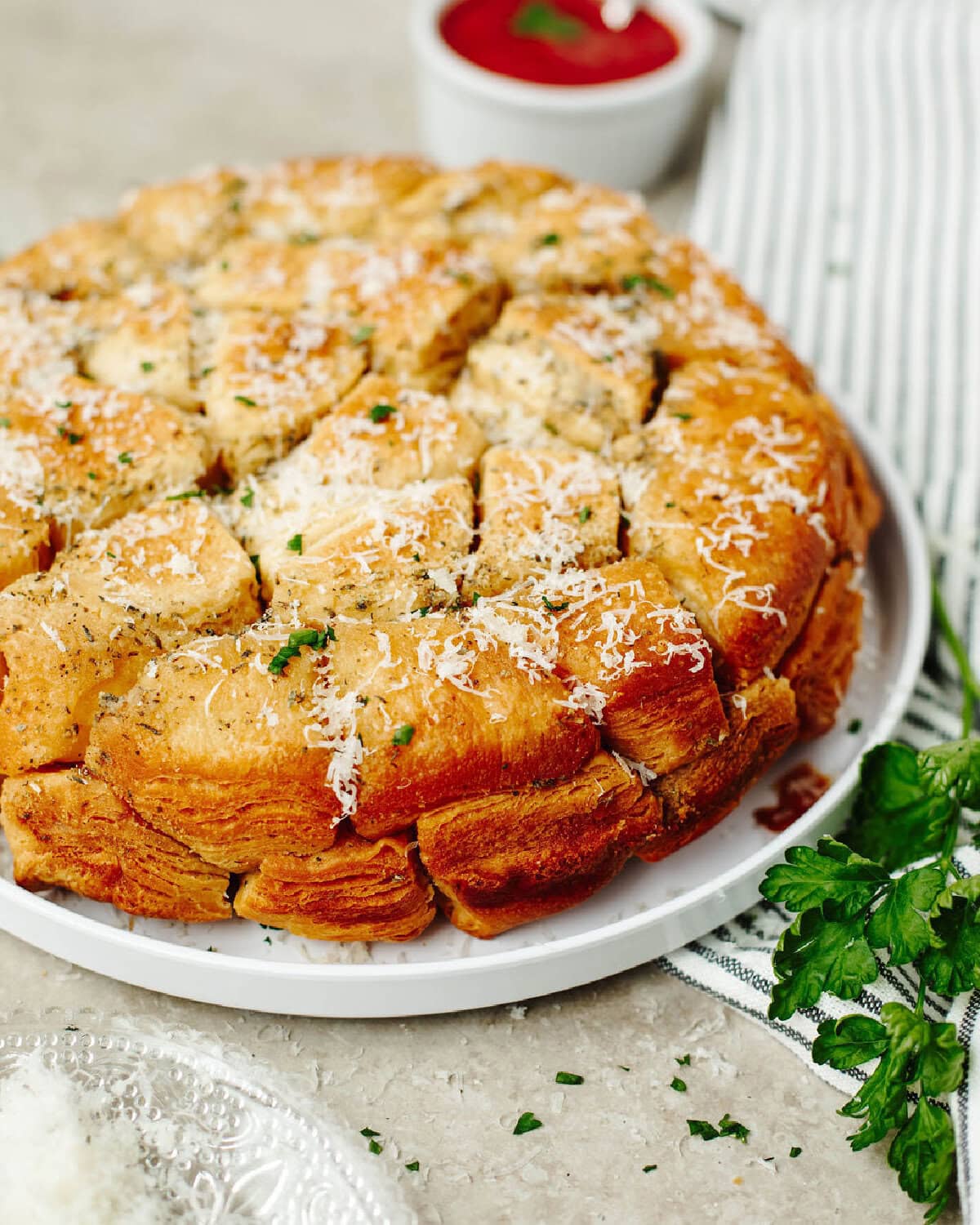 Baked biscuit pieces with a garlic butter sauce and served on a white plate.