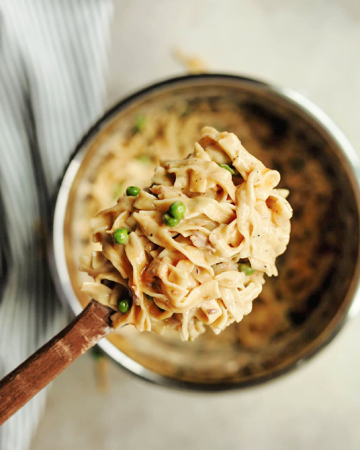 A wood spoon scooping cooked tuna casserole from the Instant Pot.