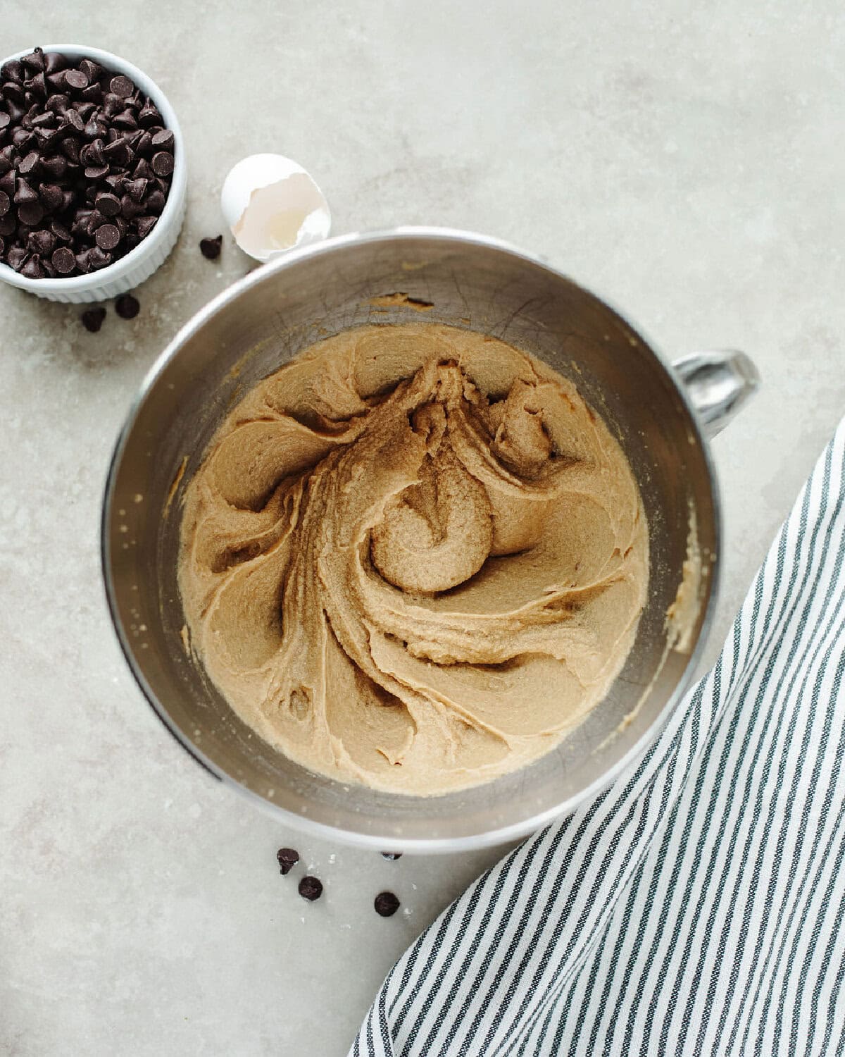 Butter, brown sugar, and eggs creamed together in a mixing bowl.