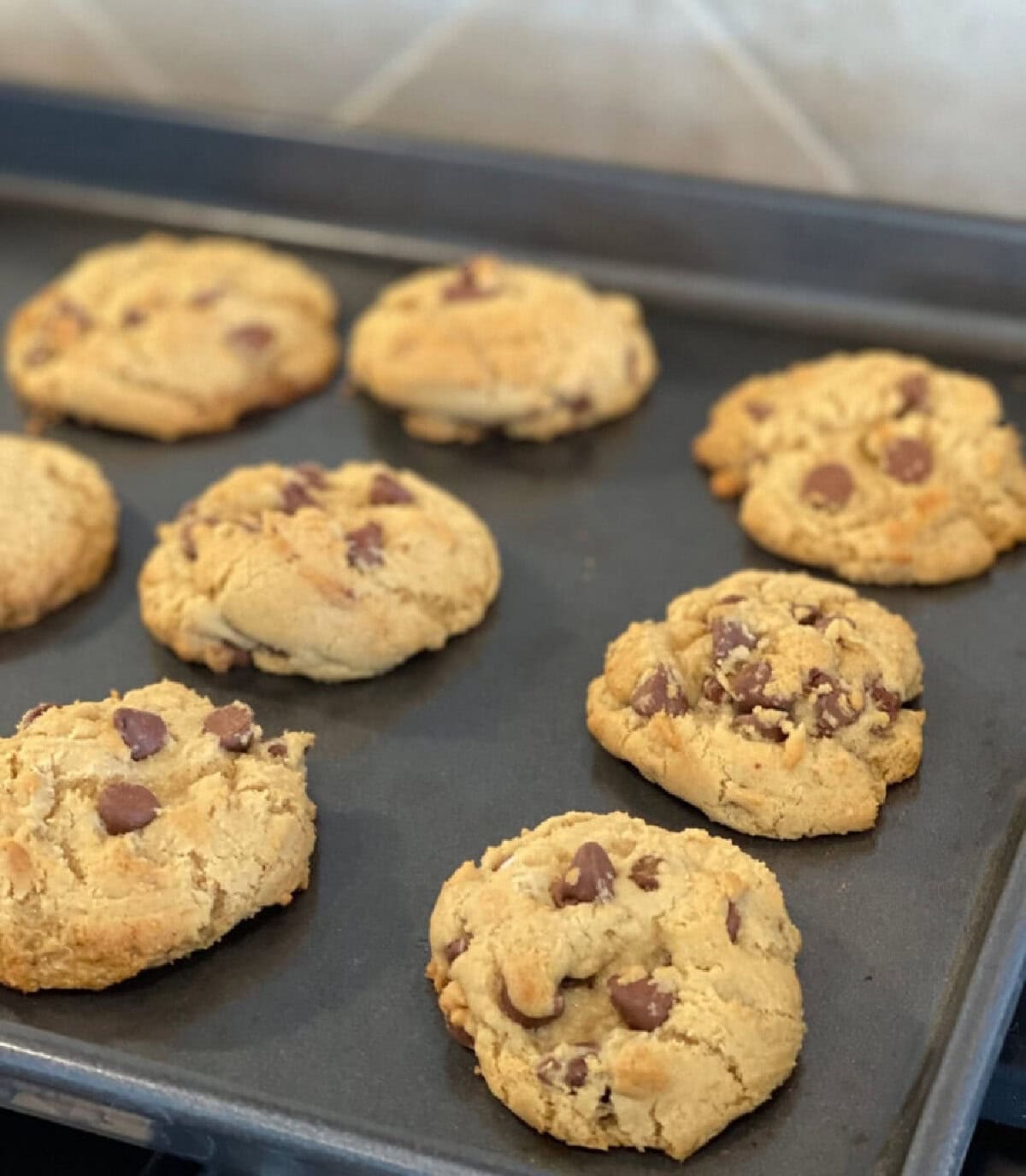 Baked chocolate chip cookies on a baking sheet.