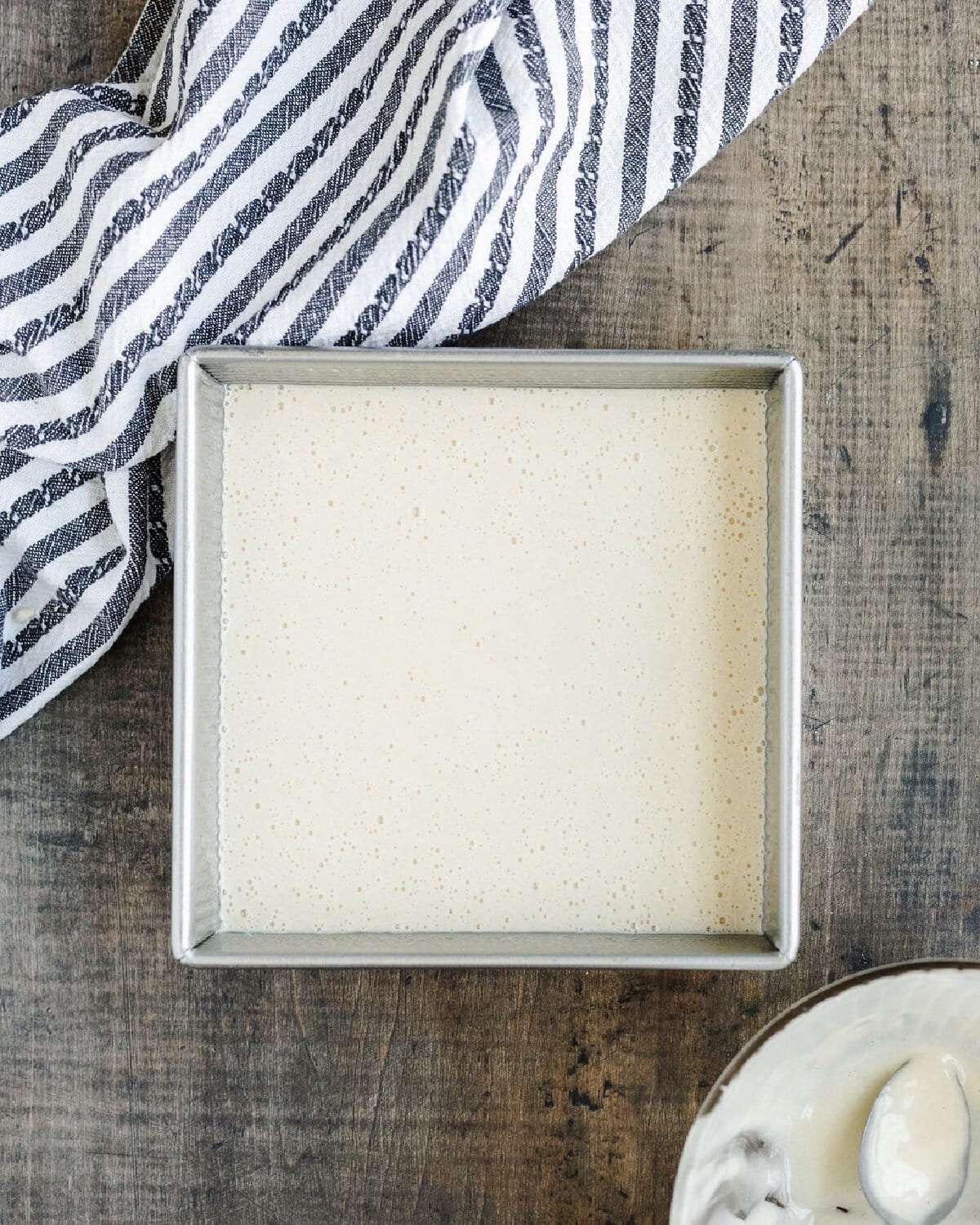 Cake batter spread evenly into an 8x8 baking pan.