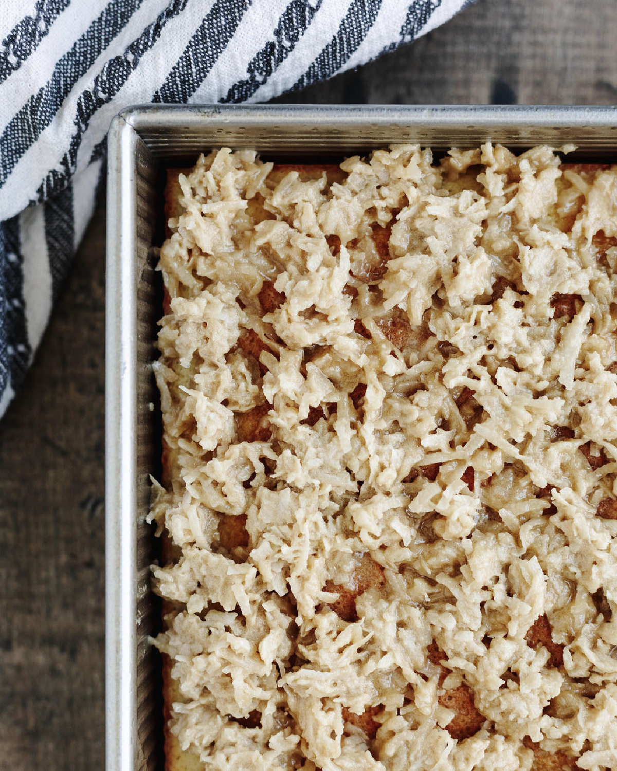 Coconut topping spread evenly on top of cake.