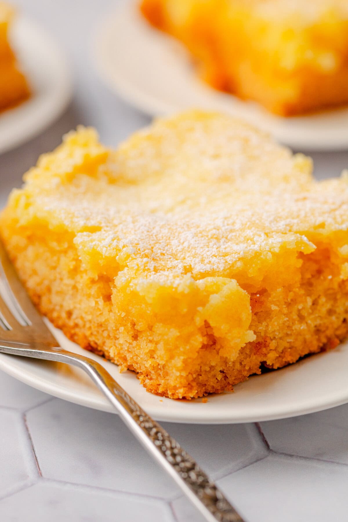 A slice of butter cake served on a white plate with a fork.