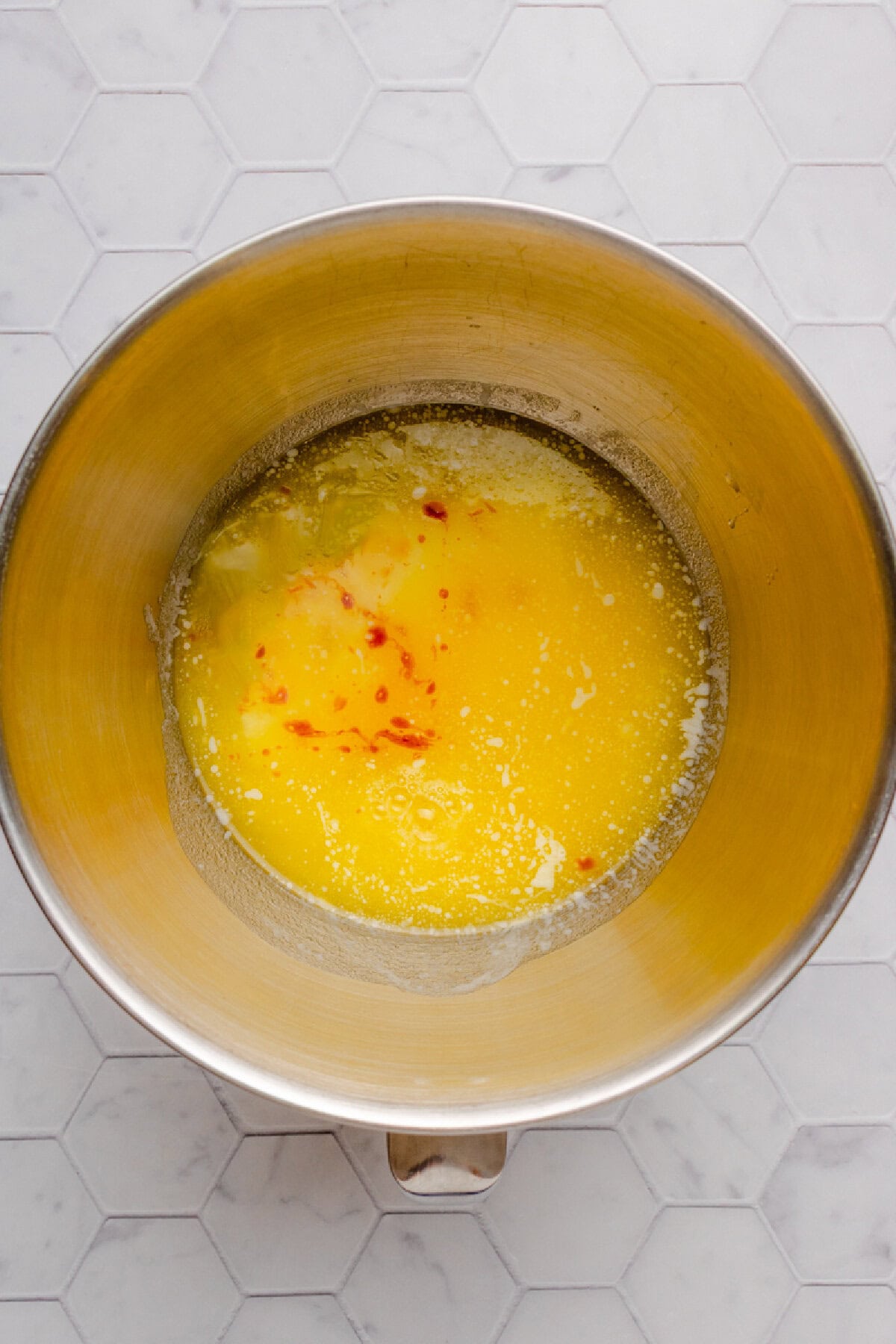 Egg and melted butter combined in a mixing bowl.