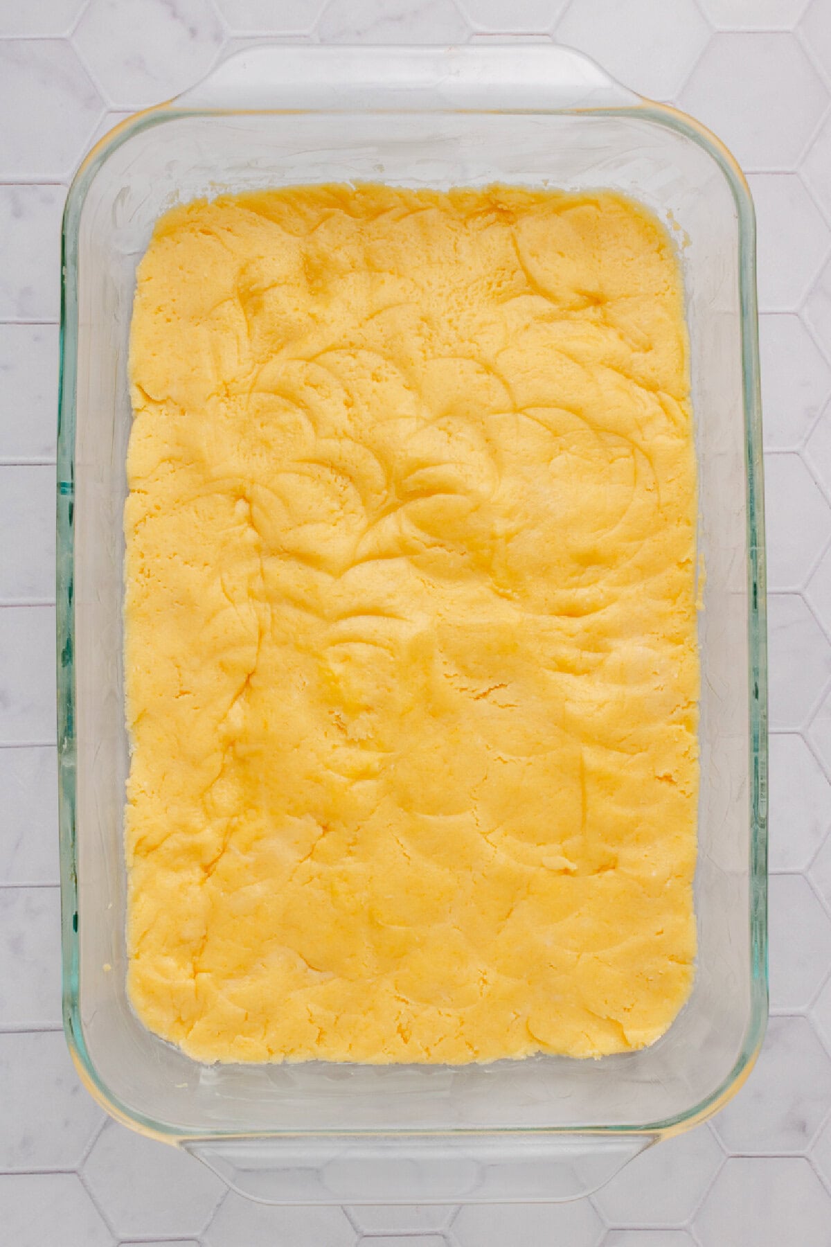 Cake mix, egg, and melted butter combined and patted firmly onto the bottom of a prepared baking pan.