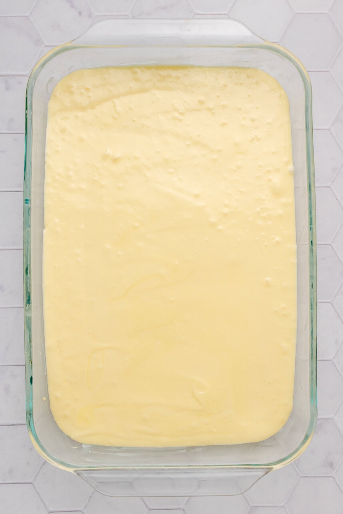 Cake batter spread evenly into a prepared baking pan.