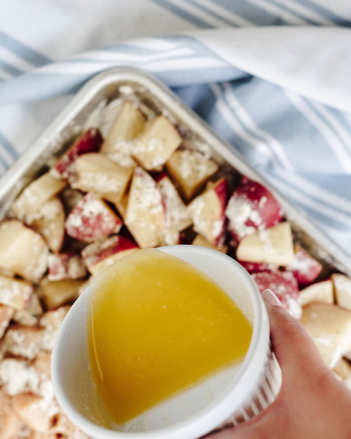 Melted butter in a small white bowl, ready to pour onto diced ingredients.