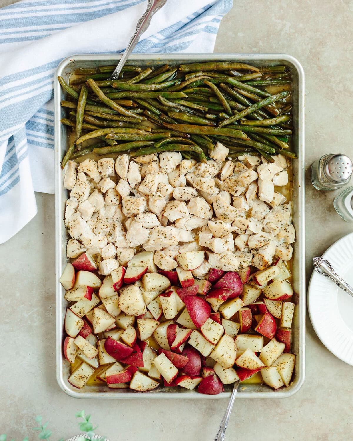An overhead view of sheet pan chicken potatoes and green beans.