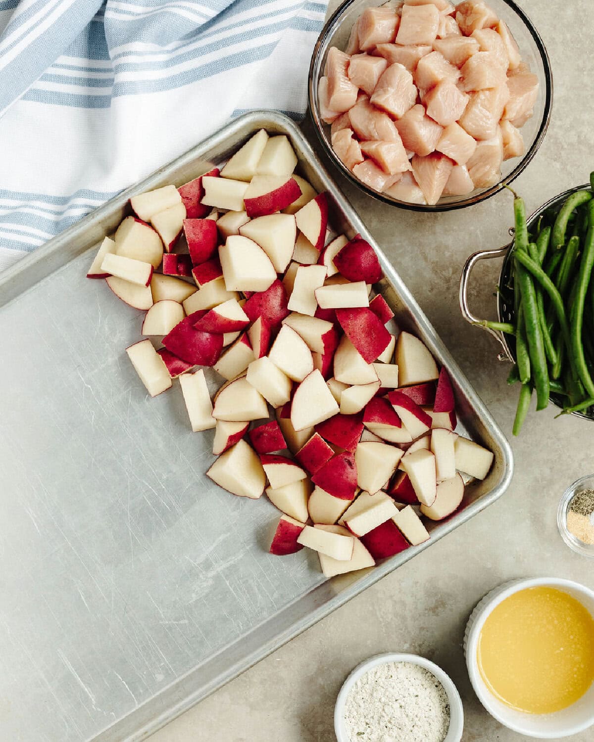 Diced potatoes lined on a cookie sheet.