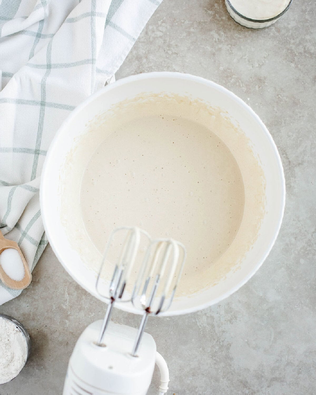 Eggs, brown sugar, and white sugar combined in a mixing bowl using an electric mixer.