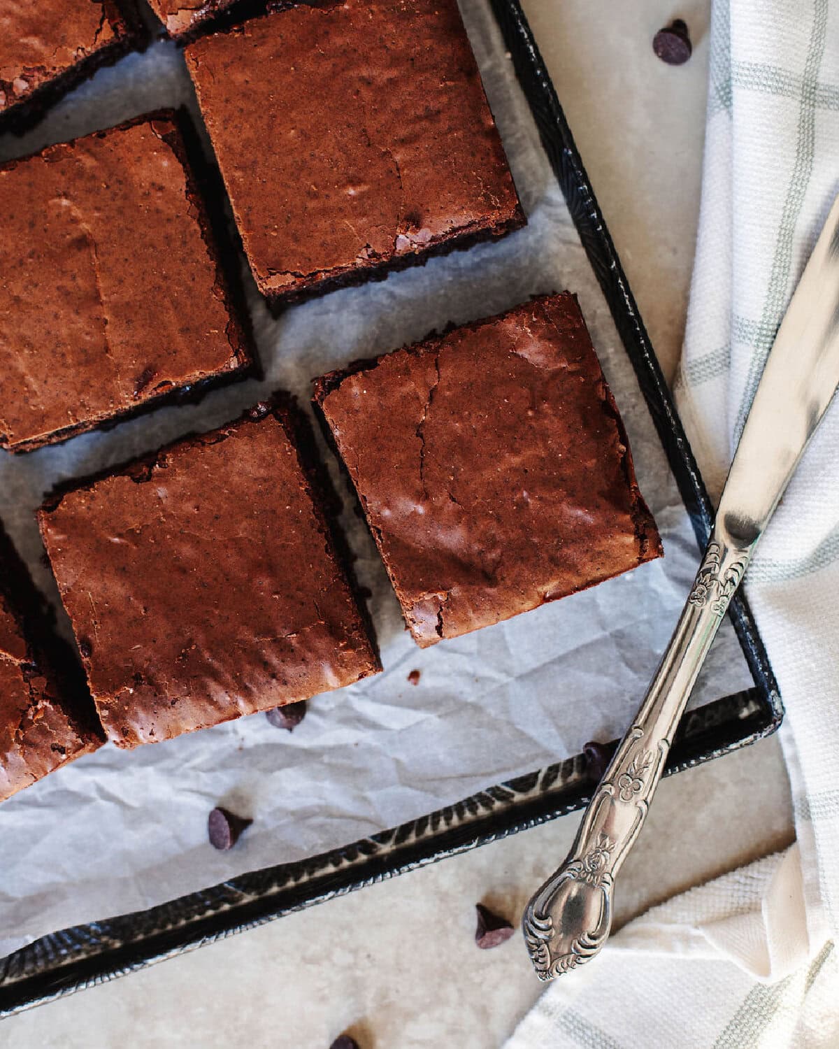 Baked and sliced sourdough discard brownies on parchment paper ready to serve.
