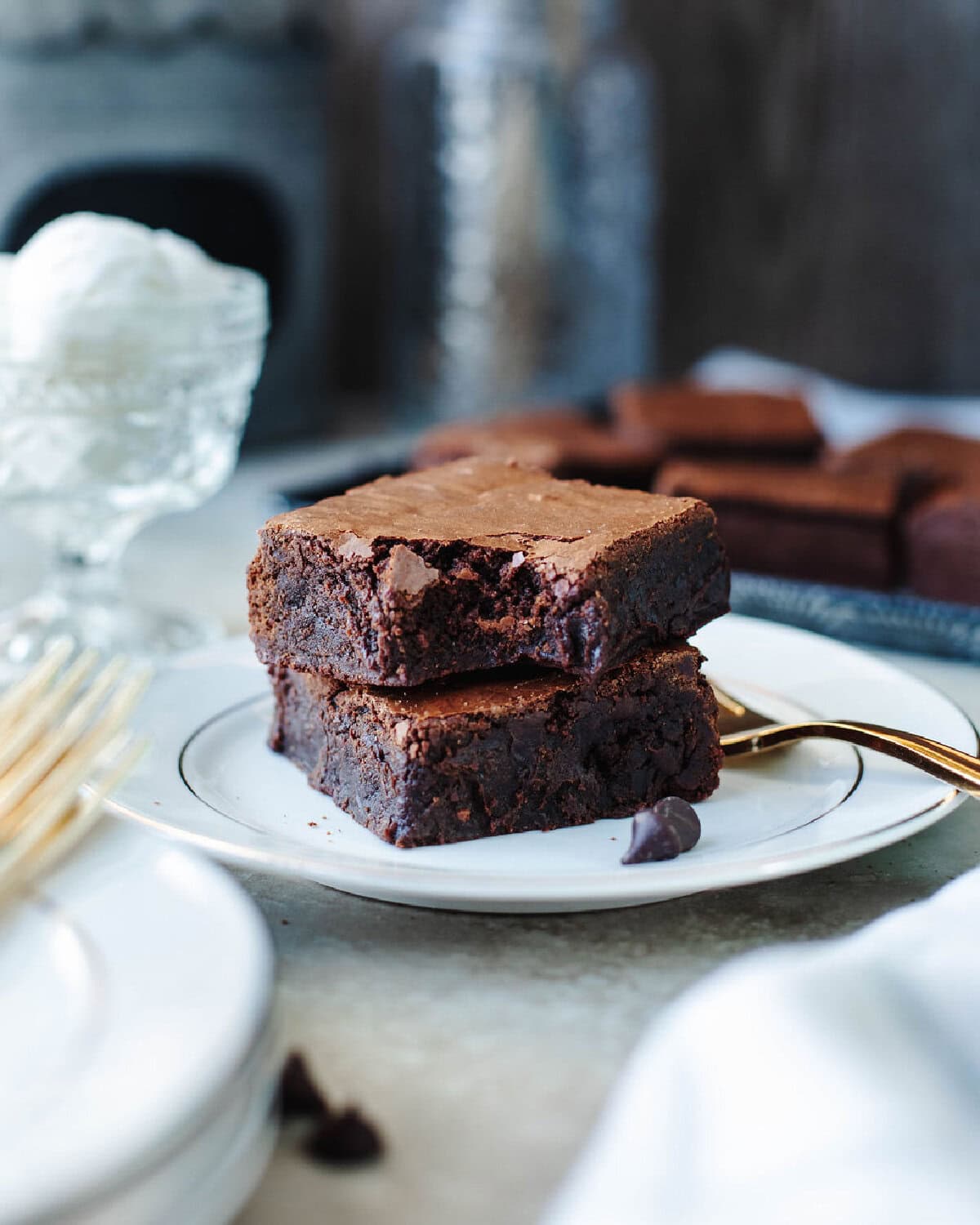 Stacked sourdough discard brownies on a white plate.