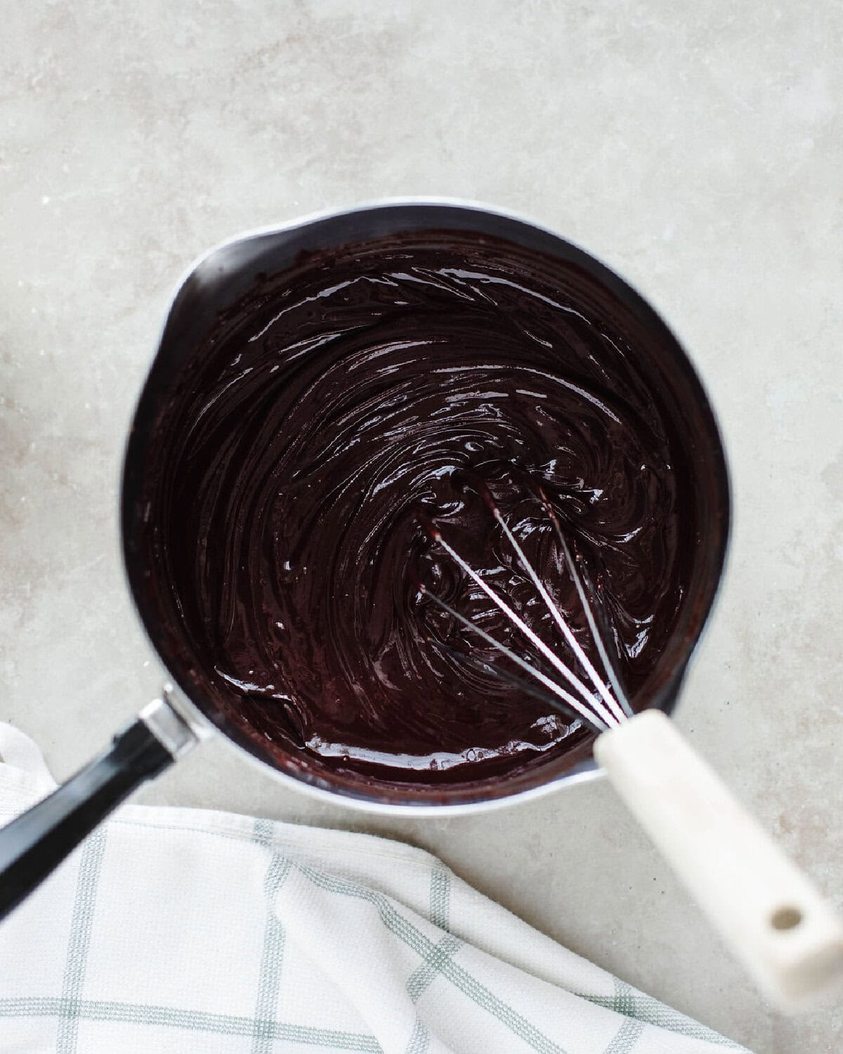 Melted butter, cocoa powder, vanilla, and chocolate chips whisked until smooth in a saucepan.
