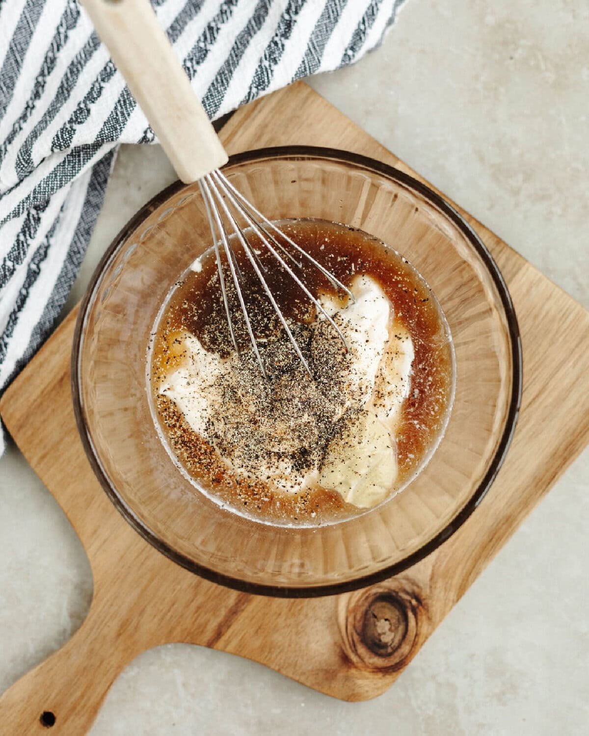 Mayonnaise, vinegar, Worcestershire sauce, and seasonings whisked together in a bowl.