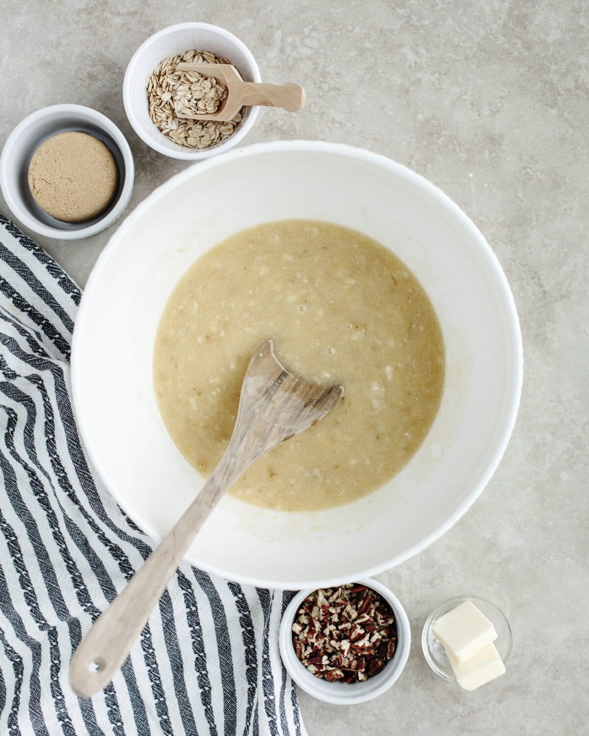 Mashed bananas, sugar, egg, vanilla, and melted butter combined in a mixing bowl.