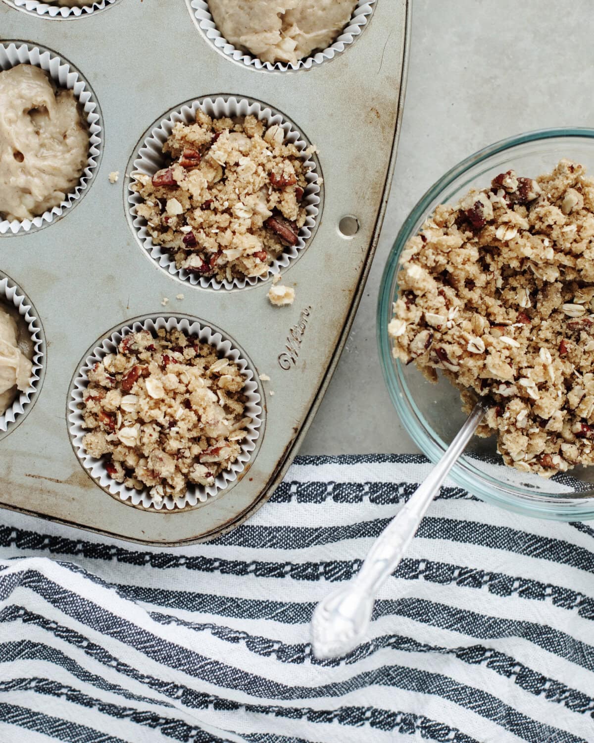 Crunchy cinnamon streusel topping sprinkled on top of muffin batter.