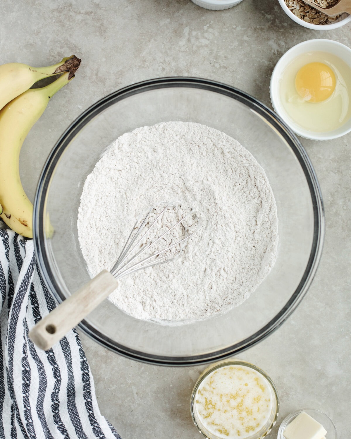 Flour, cinnamon, baking powder, baking soda, and salt combined in a glass bowl using a whisk.