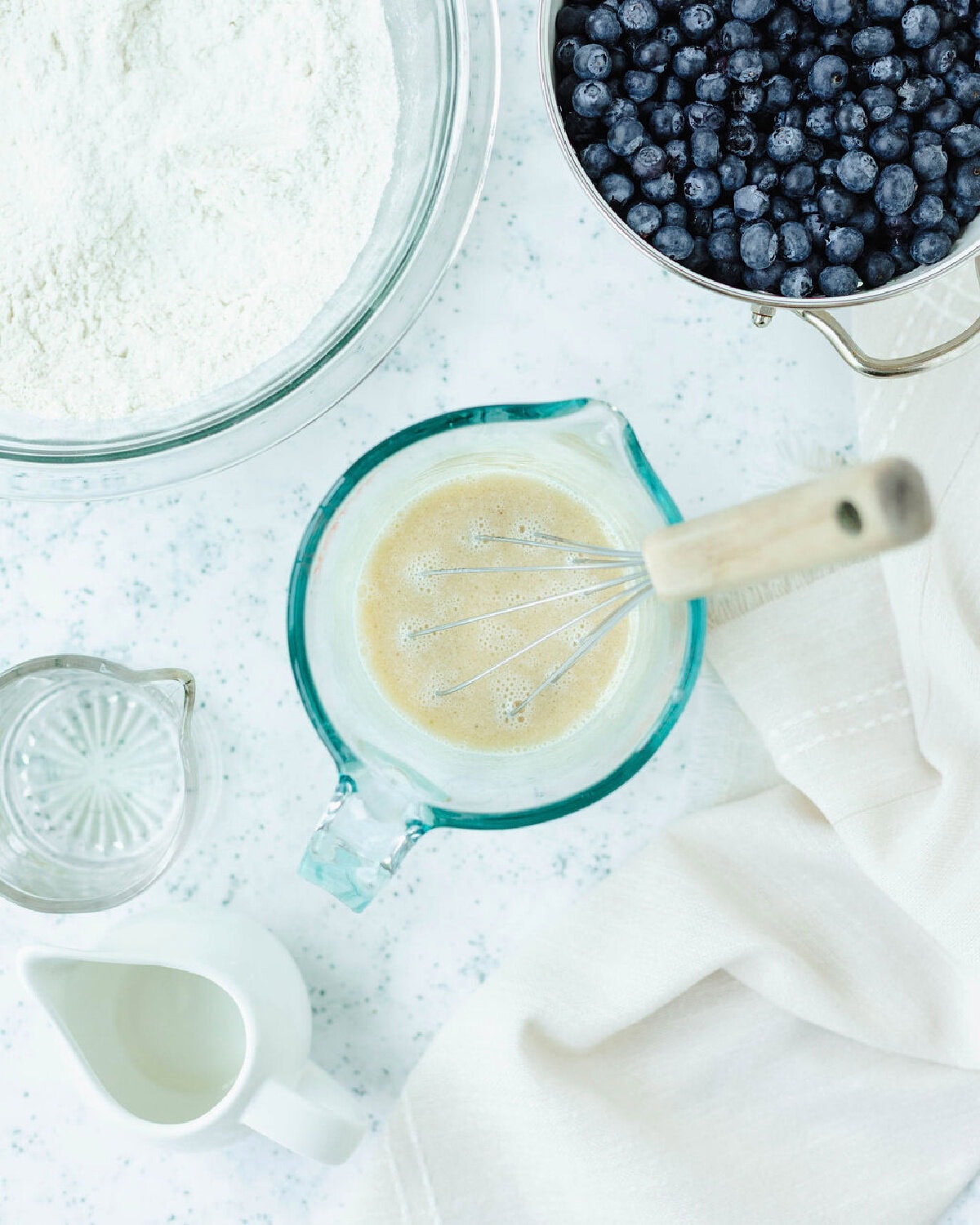 Vegetable oil, egg, and milk combined in a glass measuring cup.