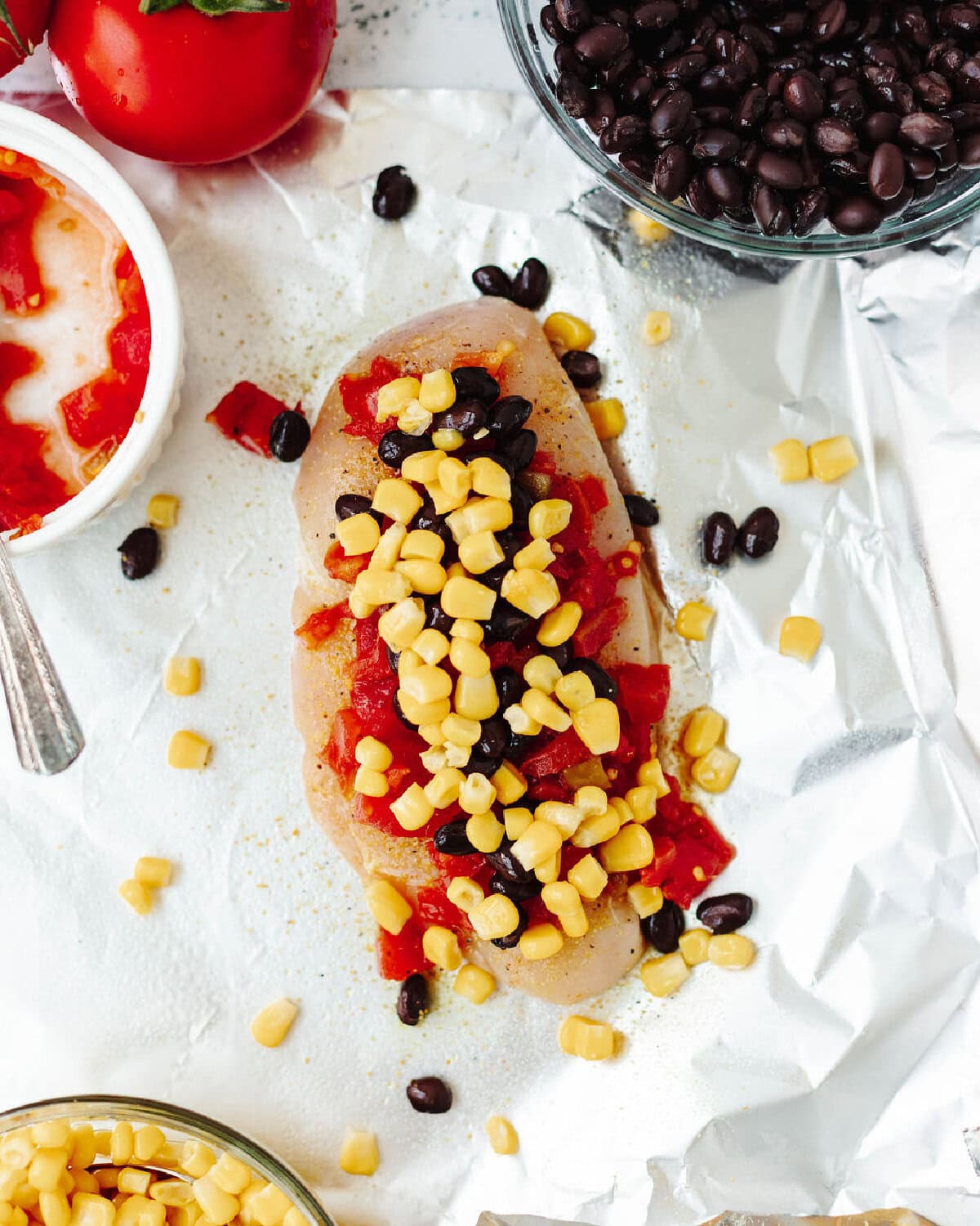 Fresh corn, black beans, and Rotel covering a seasoned chicken breast.