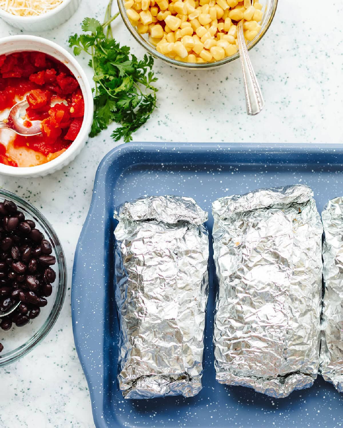 Foil packets on a serving tray after cooking on the grill.
