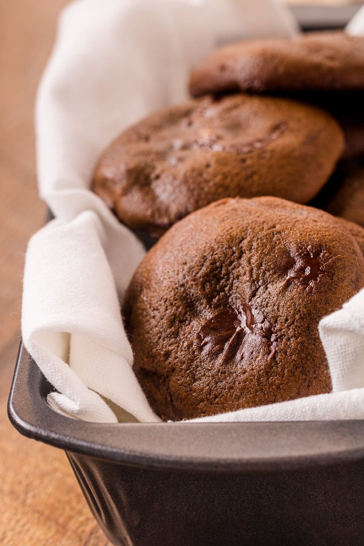 A baking pan with baked chocolate brownie cookies inside.