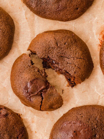 A chocolate brownie cookie broken in half to show ooey gooey center.