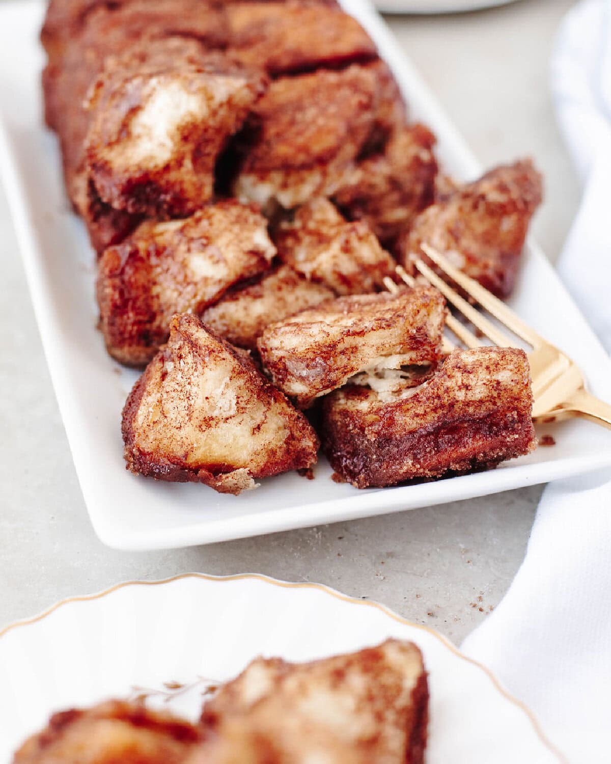 cinnamon sugar pull apart loaf on a white serving platter.