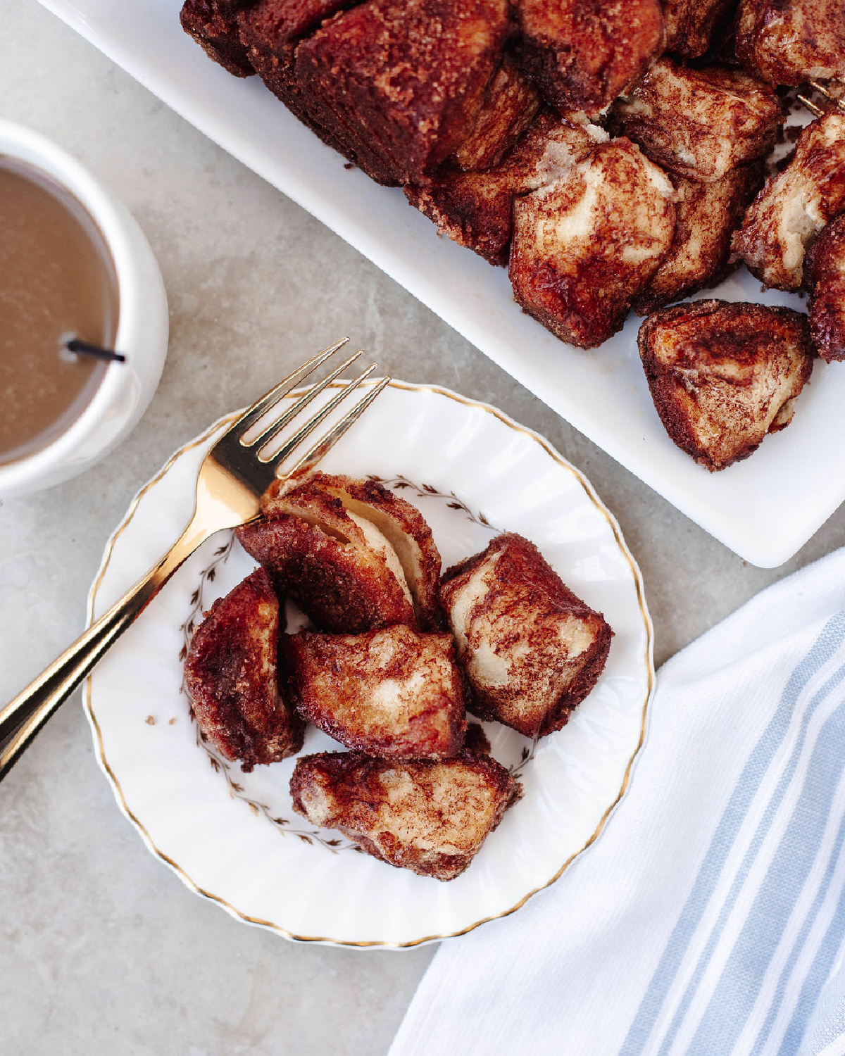 Cinnamon sugar pull apart bread served on a white plate with a fork.