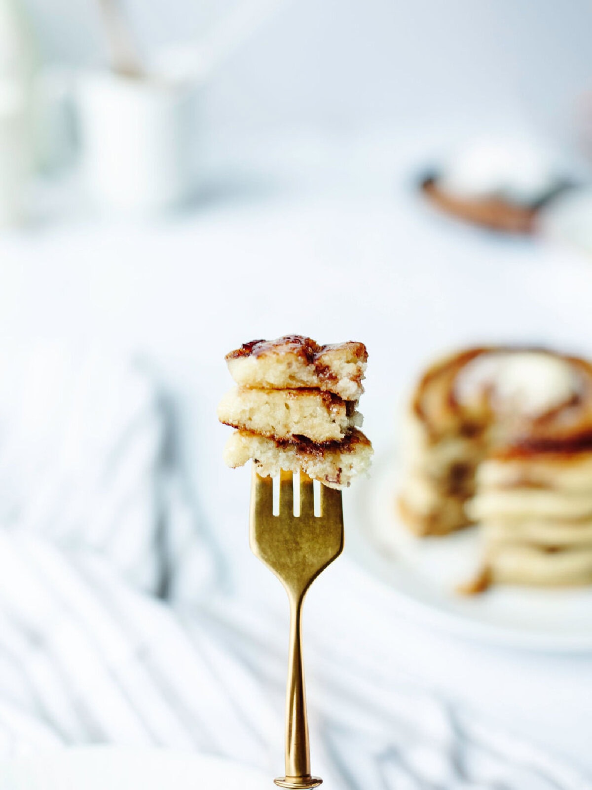 A bite of cinnamon swirl pancakes on a fork.
