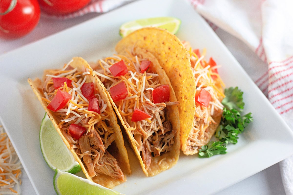 Ranch chicken tacos in a crunchy shell with shredded cheese and tomatoes.