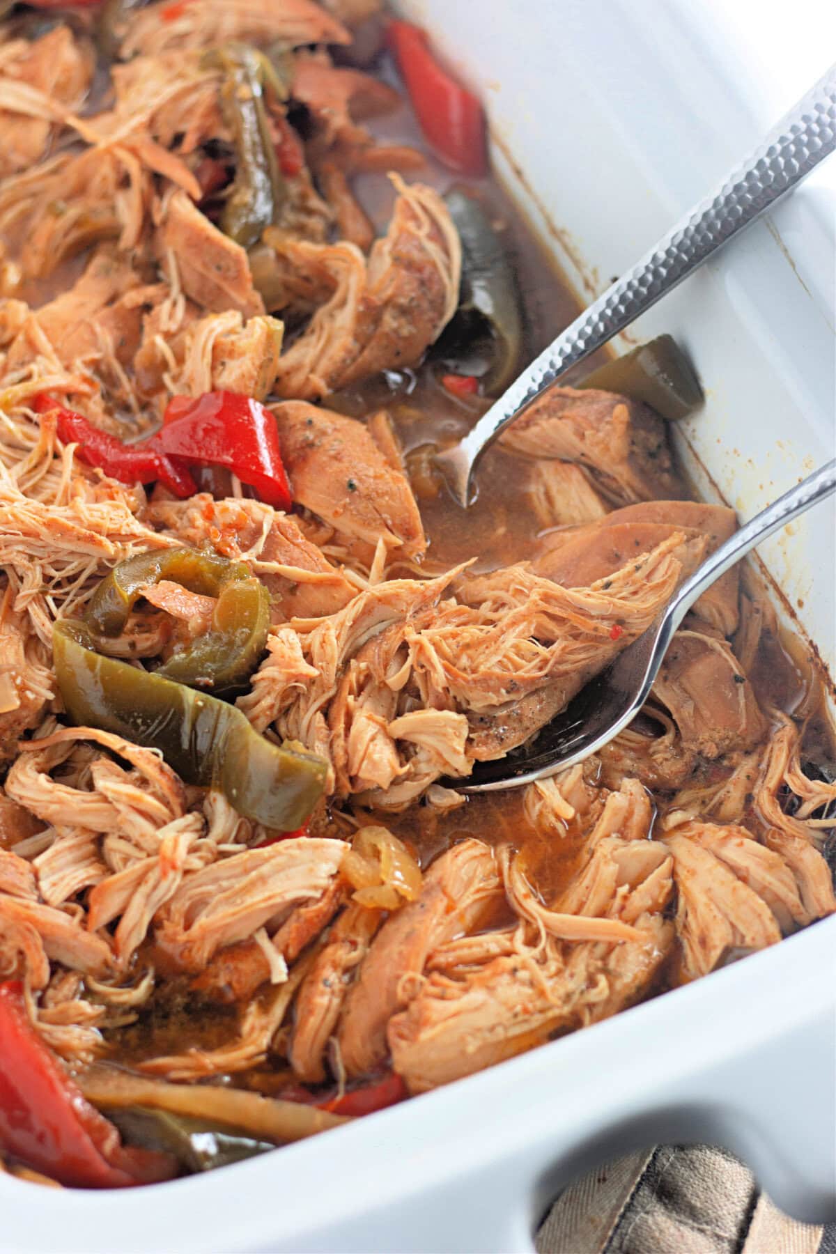 Shredded chicken and peppers in a slow cooker liner.