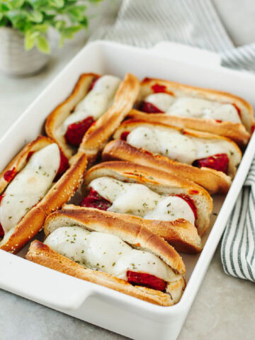 A white baking dish with easy meatball subs ready to enjoy.