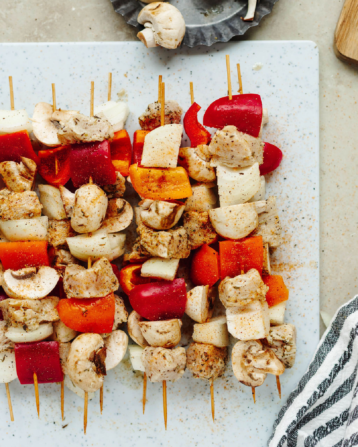 Chicken, mushroom, onion, and peppers on a skewer wood stick ready to grill.
