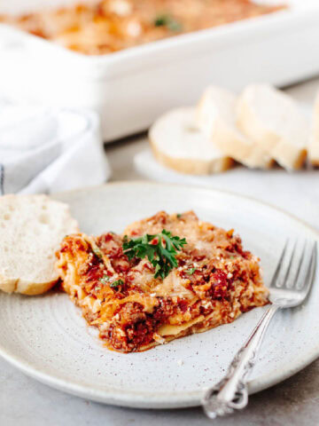 Close-up of a cheesy homemade lasagna slice with seasoned beef, cottage cheese, and melted mozzarella.