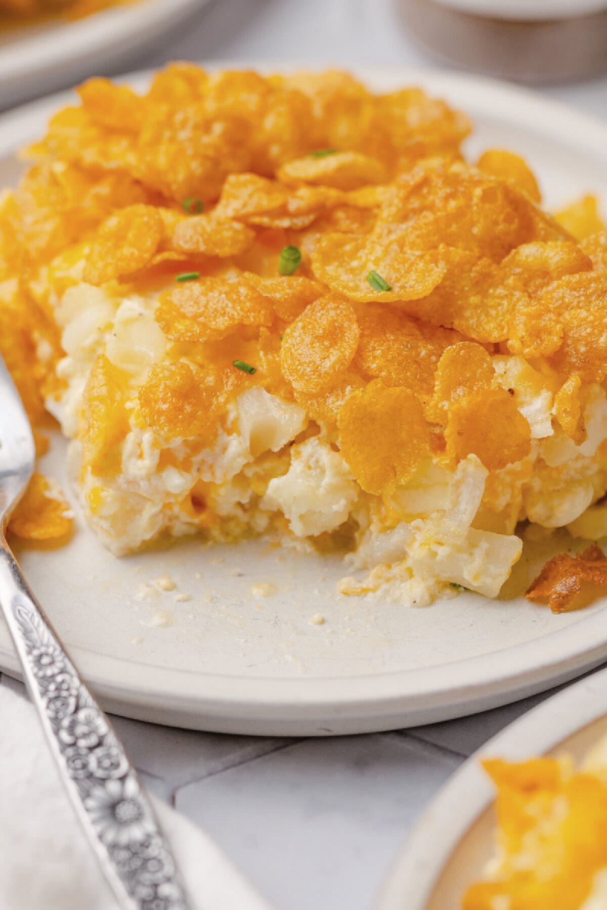 Hash Brown Potato Bake served on a white plate with a fork.