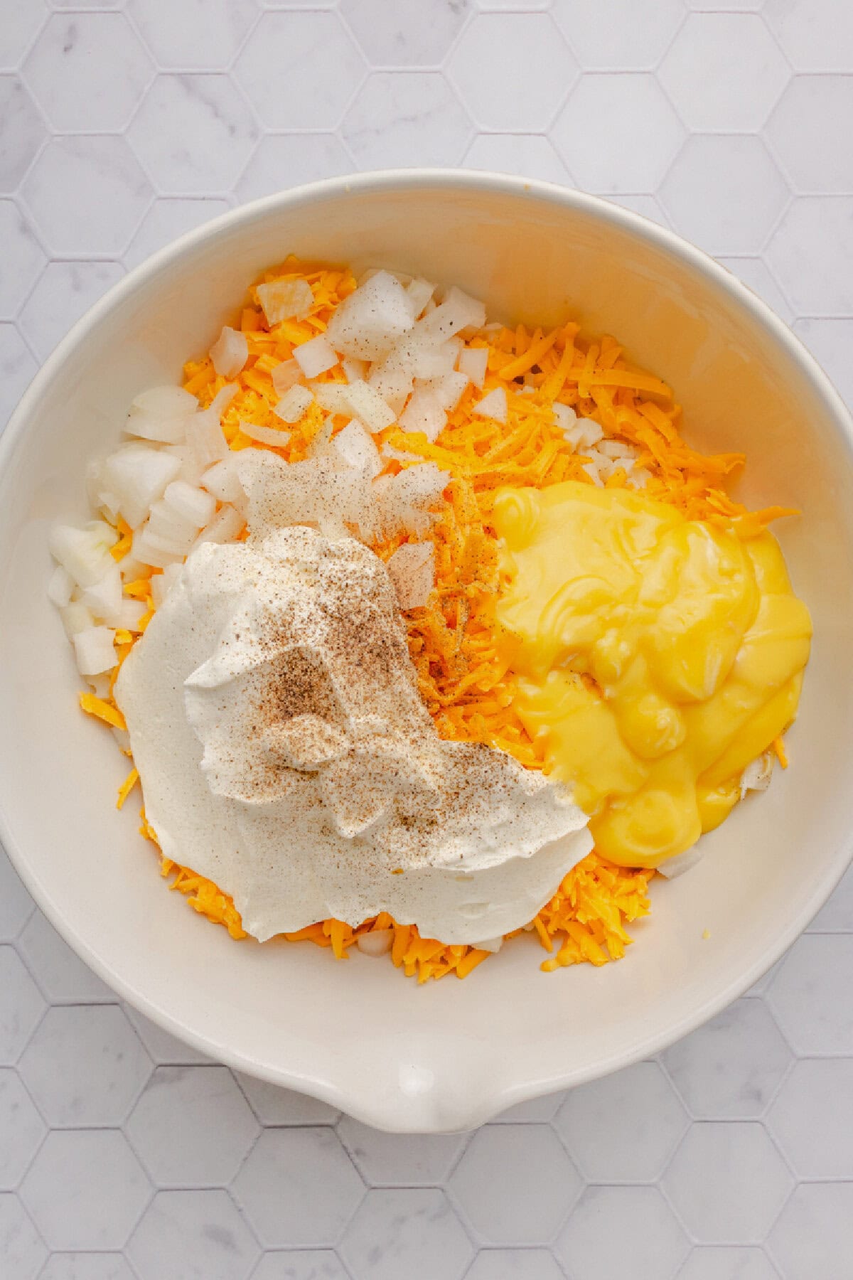 All the ingredients needed to make funeral potatoes added to a mixing bowl.