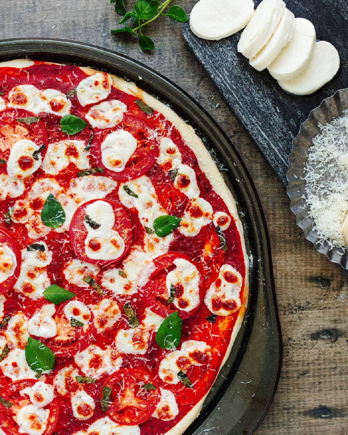 A top look at a baked pizza ready to serve from a pizza pan.