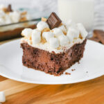 An up close look at smores poke cake with Hershey chocolate and marshmallows on top.